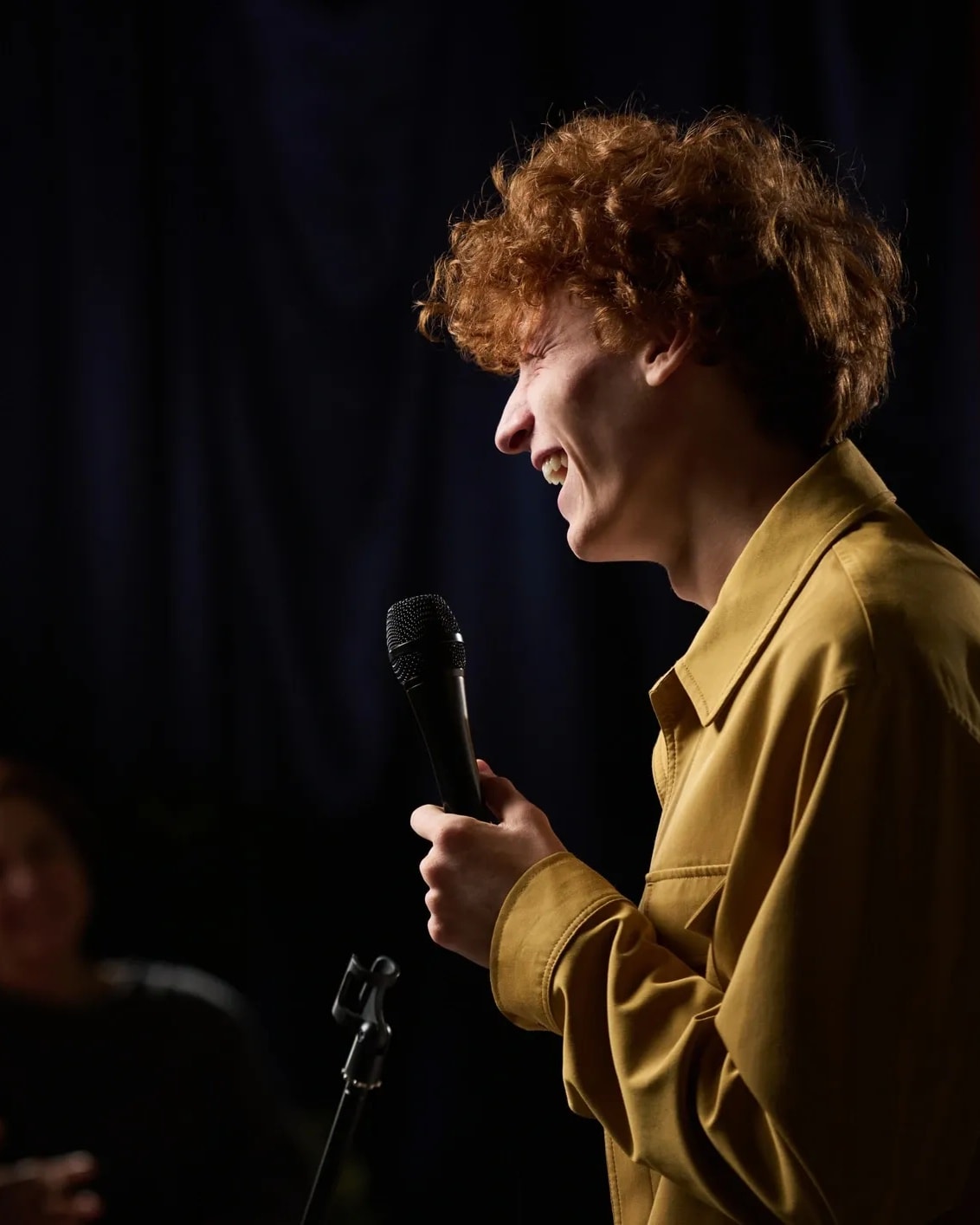 Comedian performing with a microphone on stage
